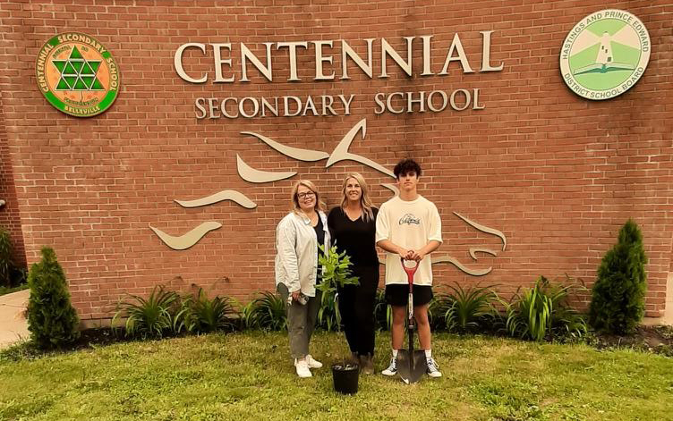 Group photo planting tree in front of Centennial Secondary School